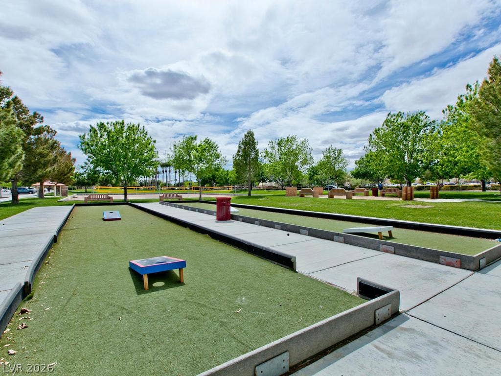 7940 Fantail Drive, North Las Vegas, NV 89084 Concrete walkways border green outdoor game courts nestled within a tree-lined community park.