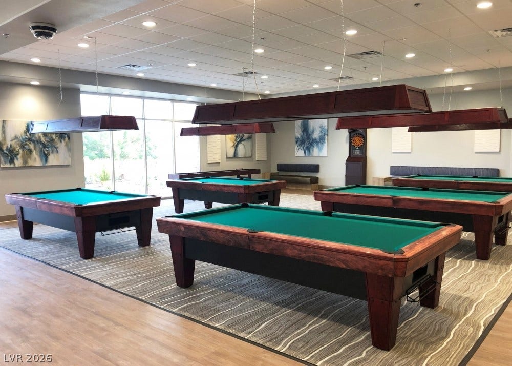 7940 Fantail Drive, North Las Vegas, NV 89084 An expansive recreation room features multiple pool tables, modern recessed lighting, and large windows.