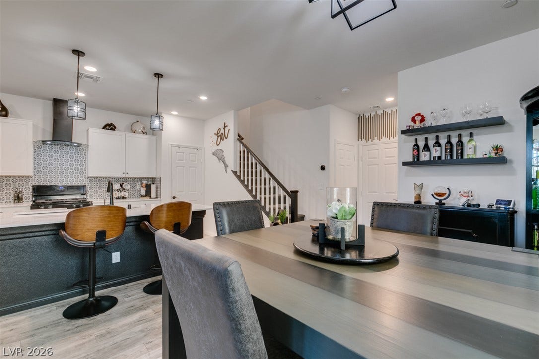 3231 Pergusa Drive, Henderson, NV 89044 An open floor plan connects the dining area to a modern kitchen and stairs.