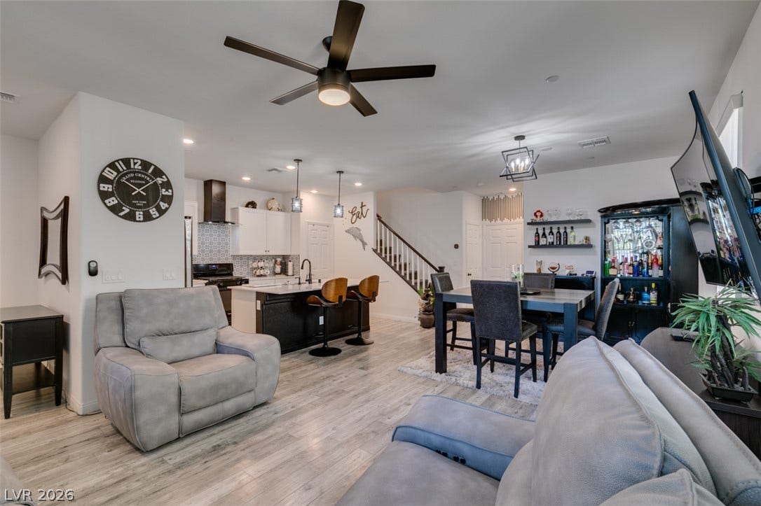 3231 Pergusa Drive, Henderson, NV 89044 An open concept main level integrates the living, dining, and kitchen areas with light wood floors.