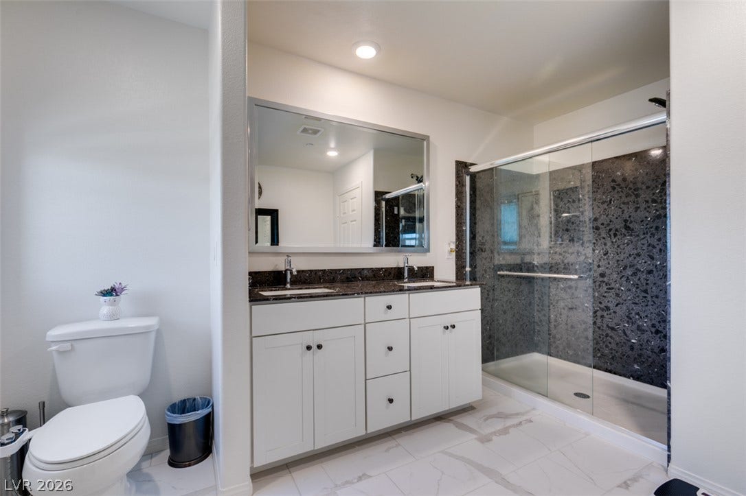 3231 Pergusa Drive, Henderson, NV 89044 Clean lines and stone counters highlight this modern bathroom complete with a dual vanity.