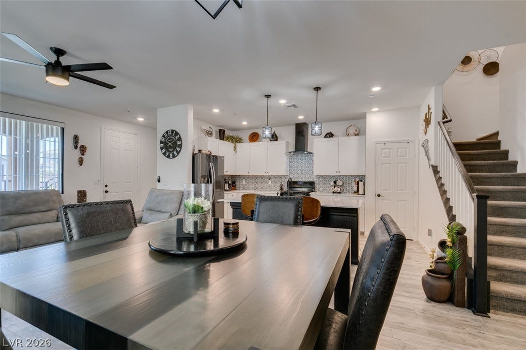 3231 Pergusa Drive, Henderson, NV 89044 An open main floor seamlessly connects the dining space, modern kitchen, and upper level stairs.