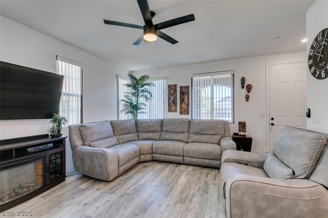 3231 Pergusa Drive, Henderson, NV 89044 Smooth wood-look flooring and integrated fireplace elevate this inviting living space.