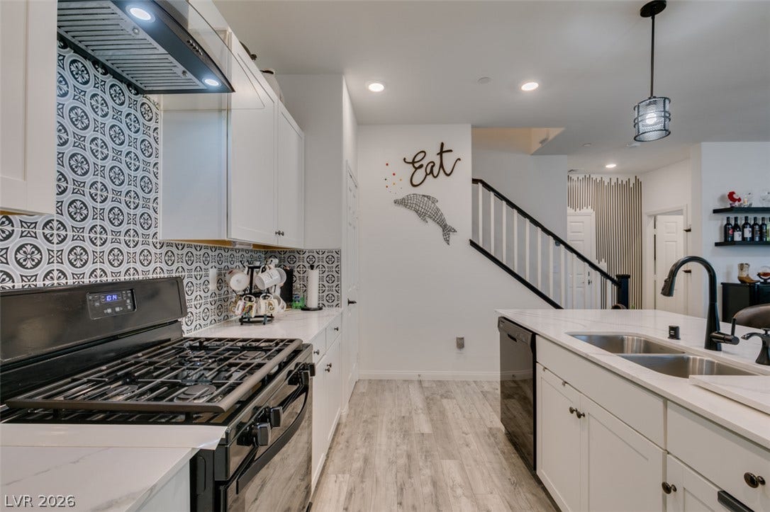 3231 Pergusa Drive, Henderson, NV 89044 Patterned tile work backdrops this modern kitchen featuring light flooring and sleek countertops.