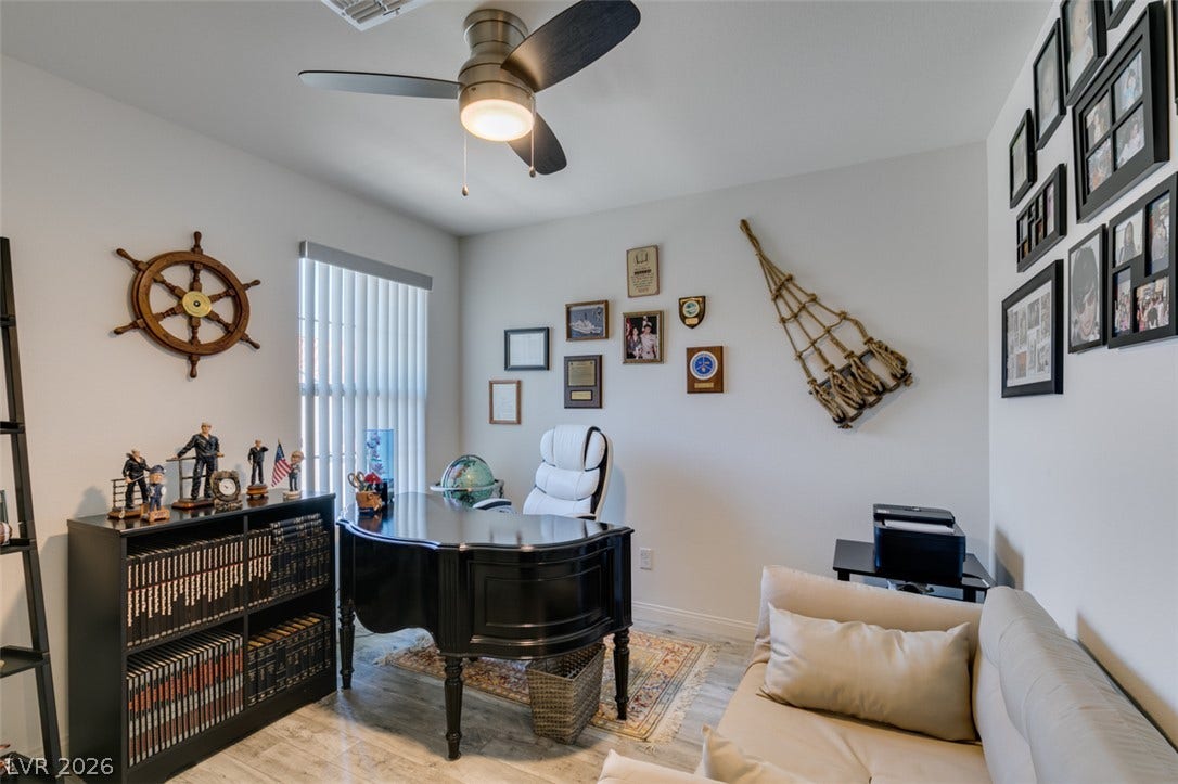3231 Pergusa Drive, Henderson, NV 89044 A spacious home workspace features durable hard-surface flooring and tall windows allowing natural light.