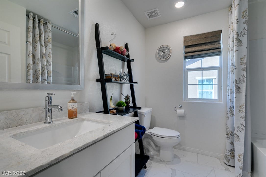 3231 Pergusa Drive, Henderson, NV 89044 Polished stone counters and clean tile flooring elevate this modern washroom.