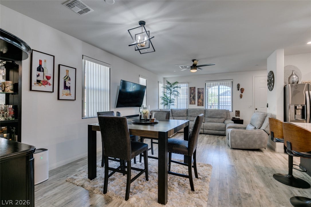 3231 Pergusa Drive, Henderson, NV 89044 An open dining area flows seamlessly into the main living space over light wood-look flooring.
