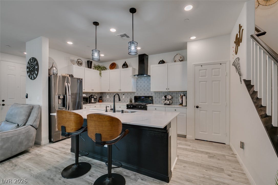 3231 Pergusa Drive, Henderson, NV 89044 An open kitchen layout showcases sleek countertops, a center island, and a modern staircase alongside.
