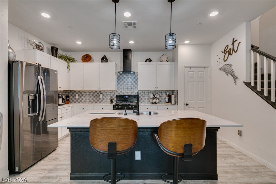 3231 Pergusa Drive, Henderson, NV 89044 Recessed lighting illuminates the central island and modern cabinetry of this open-plan kitchen.