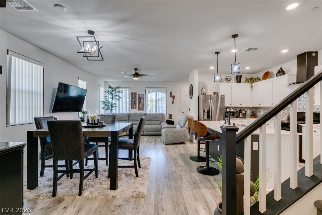 3231 Pergusa Drive, Henderson, NV 89044 An open-concept main level integrates the living, dining, and kitchen areas seamlessly over light wood-look flooring.
