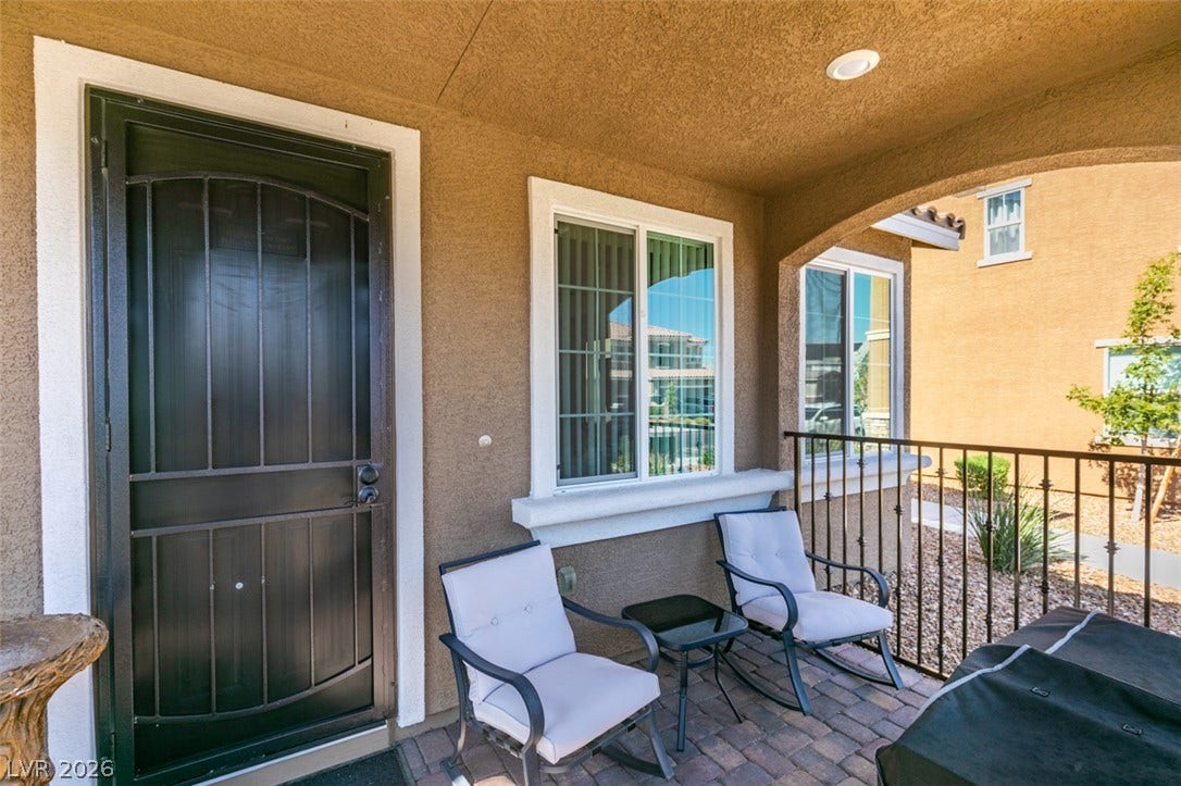 3231 Pergusa Drive, Henderson, NV 89044 An inviting covered front porch features classic stucco walls, recessed lighting, and paver flooring.