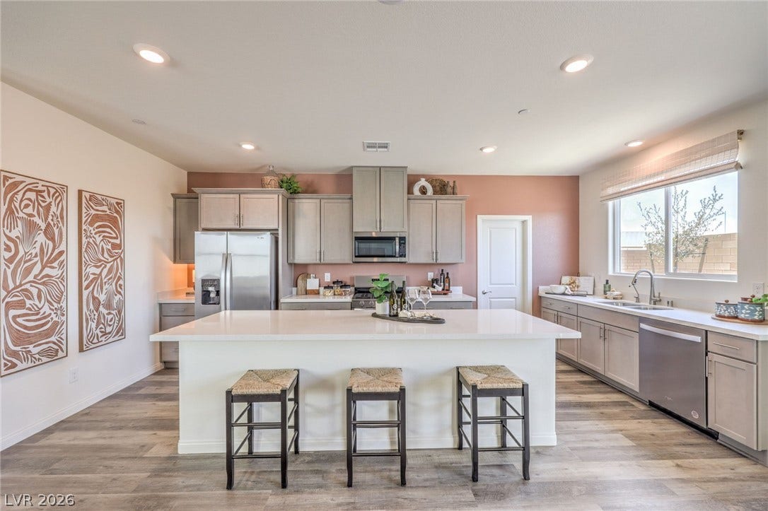 1036 PEACOCK PLUME Street, Henderson, NV 89011 Kitchen featuring appliances with stainless steel finishes, a sink, gray cabinetry, a kitchen breakfast bar, and recessed lighting. Photo is representational only; actual home finishes may vary.