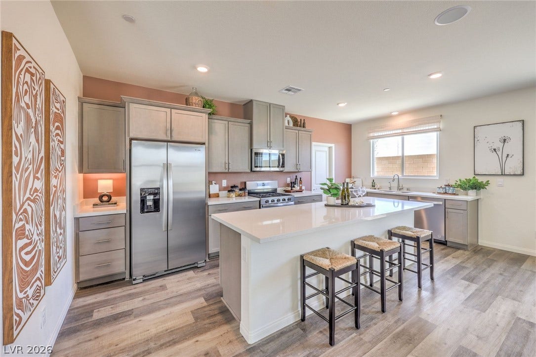 1036 PEACOCK PLUME Street, Henderson, NV 89011 Kitchen with appliances with stainless steel finishes, light wood-style. Photo is representational only; actual home finishes may vary flooring, a breakfast bar, light countertops, and recessed lighting