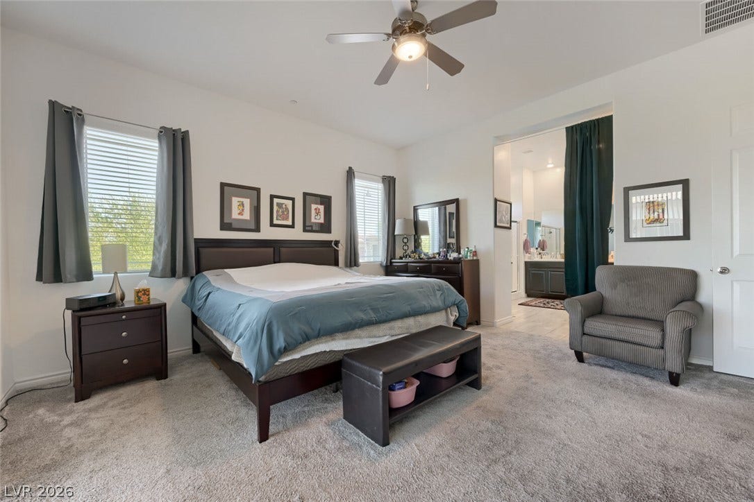 747 Orange Plume Walk, Henderson, NV 89011 Plush carpeting anchors this spacious bedroom featuring clean lines and an adjoining bathroom suite.