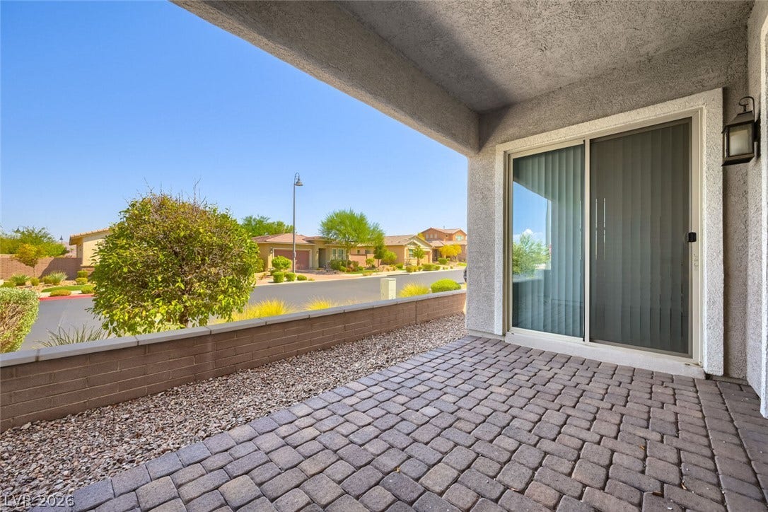 747 Orange Plume Walk, Henderson, NV 89011 An inviting covered patio features clean brick pavers looking out over the neighborhood landscape.