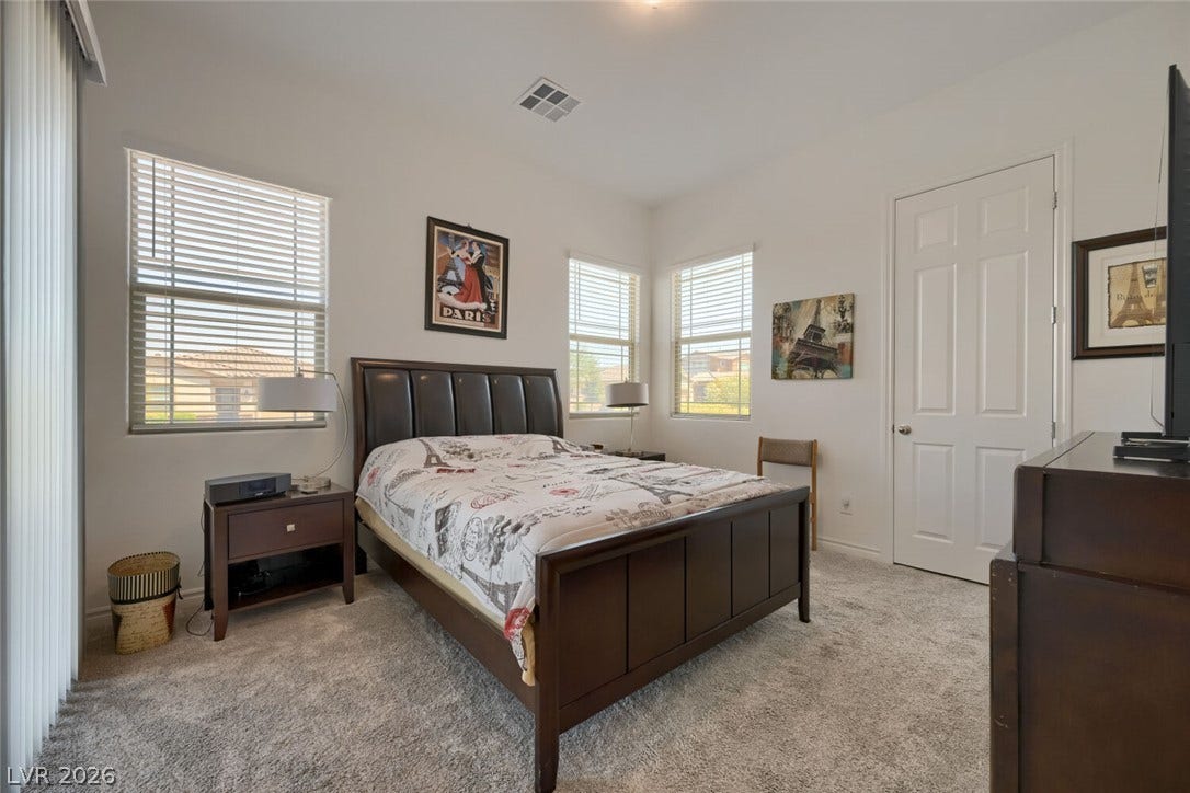 747 Orange Plume Walk, Henderson, NV 89011 Natural light streams through multiple windows onto the soft carpeted floor of this bedroom.