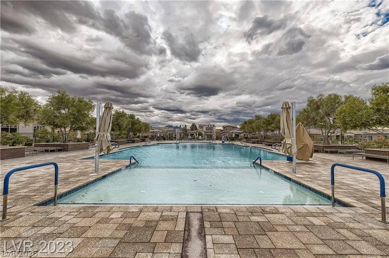 747 Orange Plume Walk, Henderson, NV 89011 An expansive community swimming pool is surrounded by extensive paver decking and lush trees.