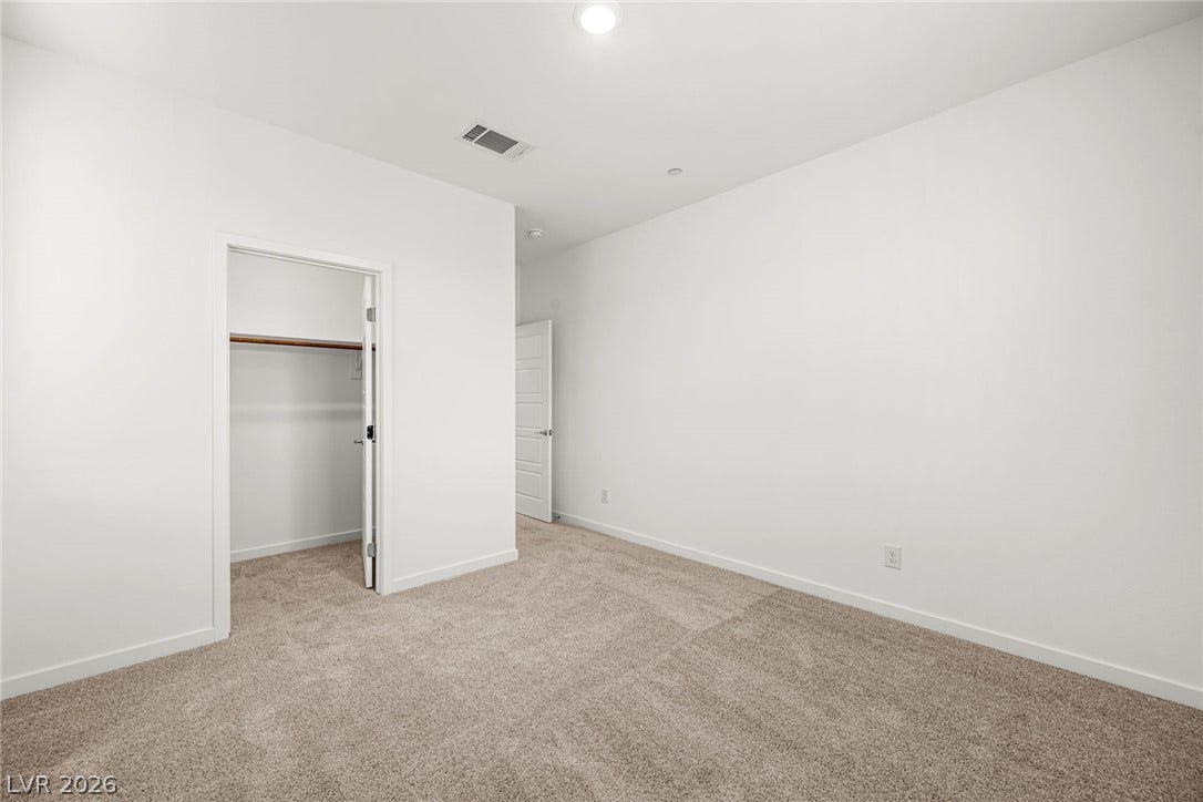 Soft carpeting underfoot provides cozy warmth in this versatile second bedroom.