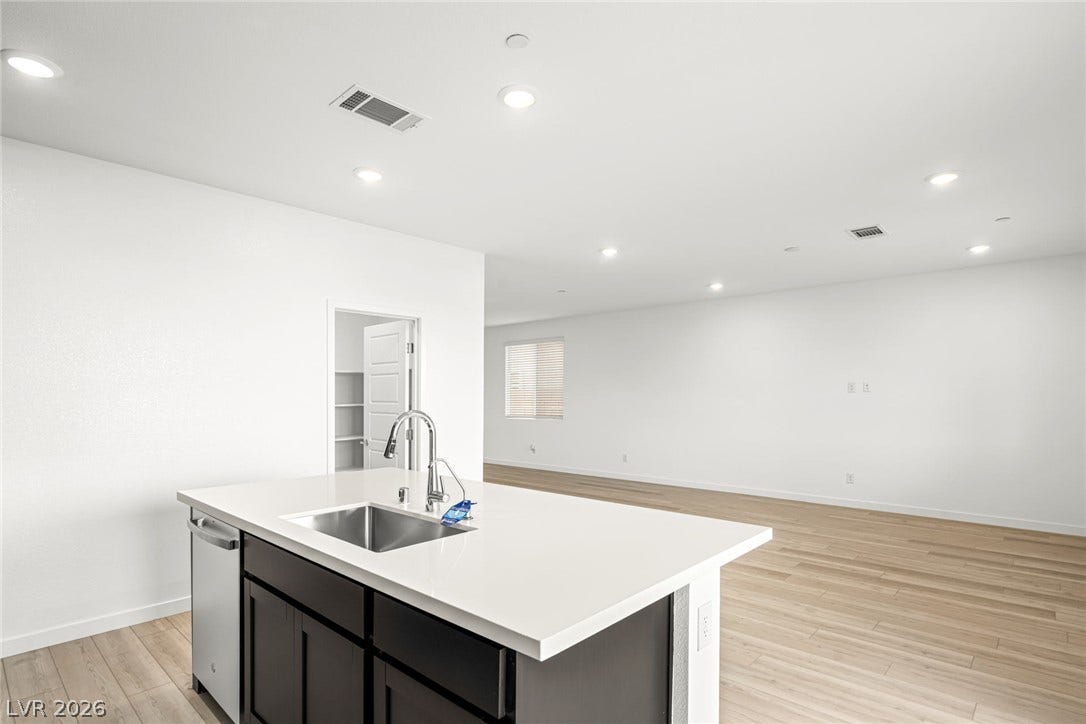 A spacious open-plan layout connects the modern kitchen island to the expansive living area.