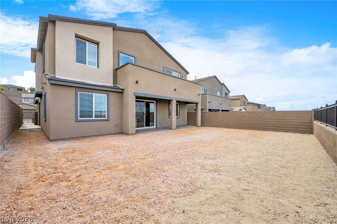 An enclosed backyard space offers potential for customization alongside the two-story home.