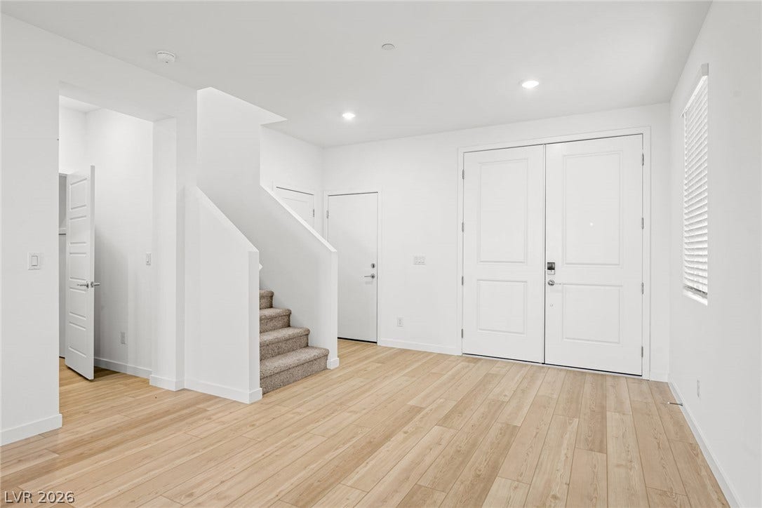 Clean lines and light wood flooring define this welcoming entrance foyer with recessed lighting.