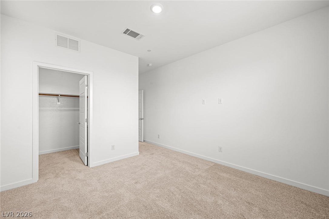 Plush carpeting and a walk-in closet highlight this versatile auxiliary room.
