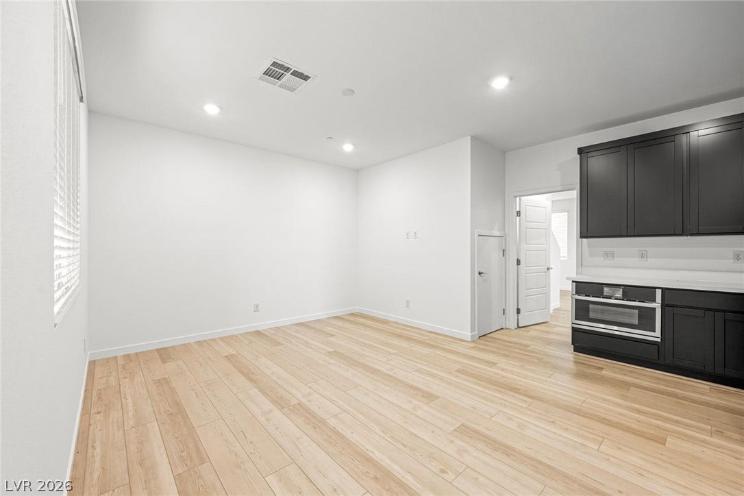 Gleaming wood floors and modern cabinetry anchor this versatile open-concept living and dining zone.