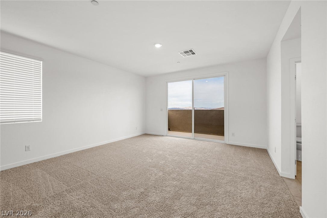 Plush carpeting fills this bedroom opening directly onto a private balcony through sliding glass doors.