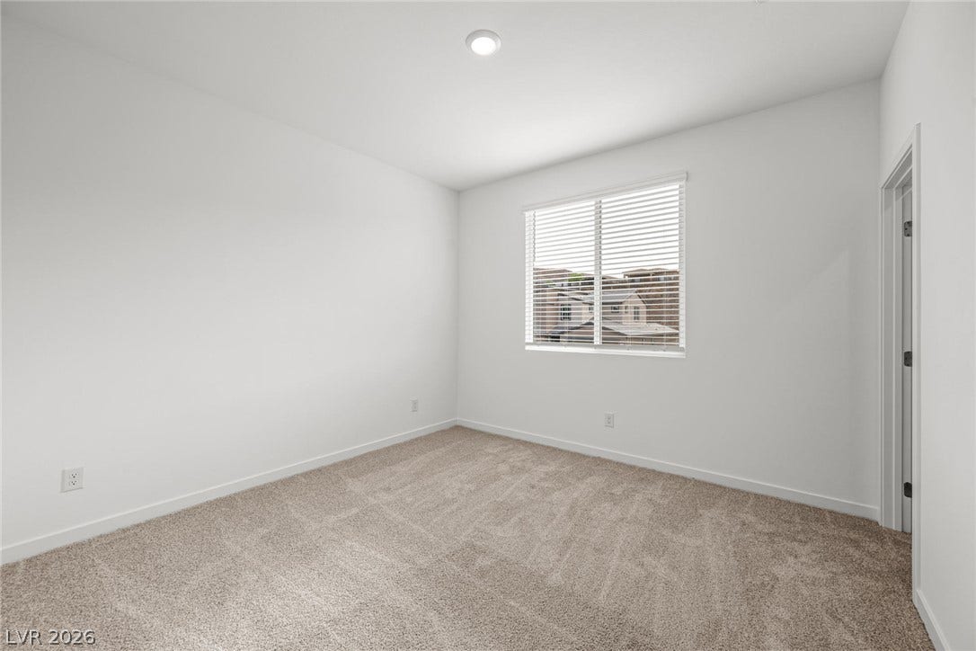 Plush carpeting and a large window create a comfortable, inviting atmosphere.