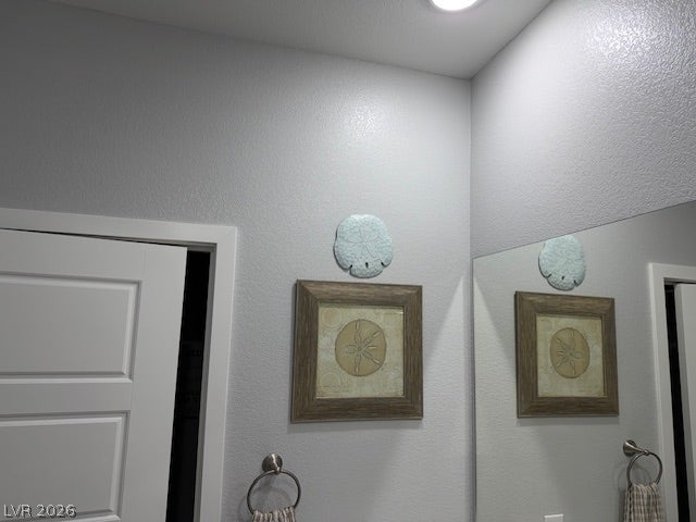 384 Aravalli Crest Street, Henderson, NV 89015 Reflective mirror and contemporary wall art create an inviting bath space.