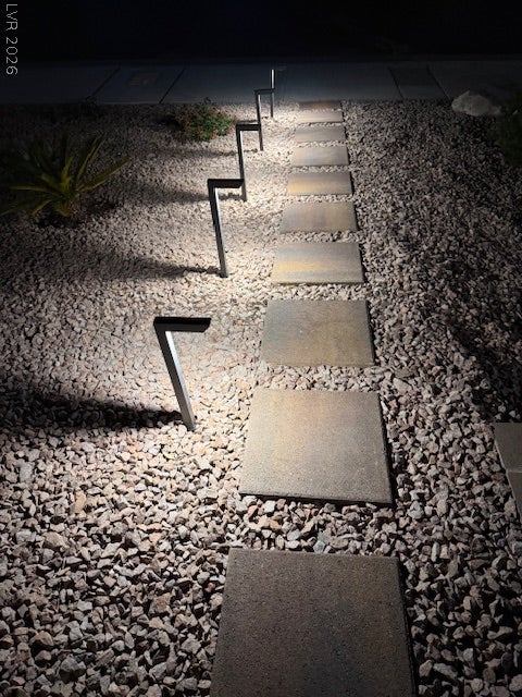 384 Aravalli Crest Street, Henderson, NV 89015 Accent lighting illuminates a contemporary pathway featuring stepping stones embedded in a gravel bed.