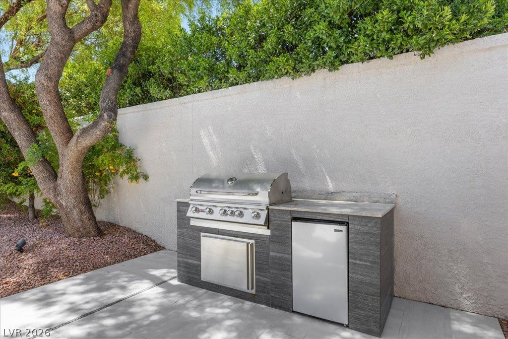 9425 Garnet Crown Avenue, Las Vegas, NV 89145 An outdoor kitchen with built-in barbecue grill and mini fridge stands ready for entertaining.