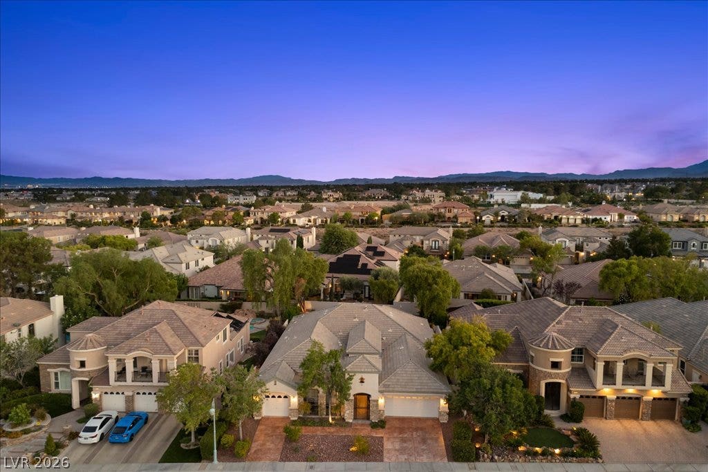 9425 Garnet Crown Avenue, Las Vegas, NV 89145 Dusk skies frame this elegant neighborhood of tiled-roof homes nestled against distant mountain ridges.
