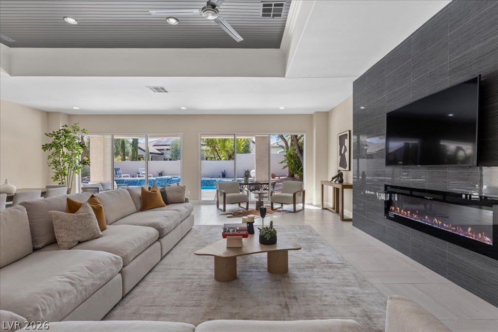 9425 Garnet Crown Avenue, Las Vegas, NV 89145 An open living space features a modern fireplace wall and views of the pool.