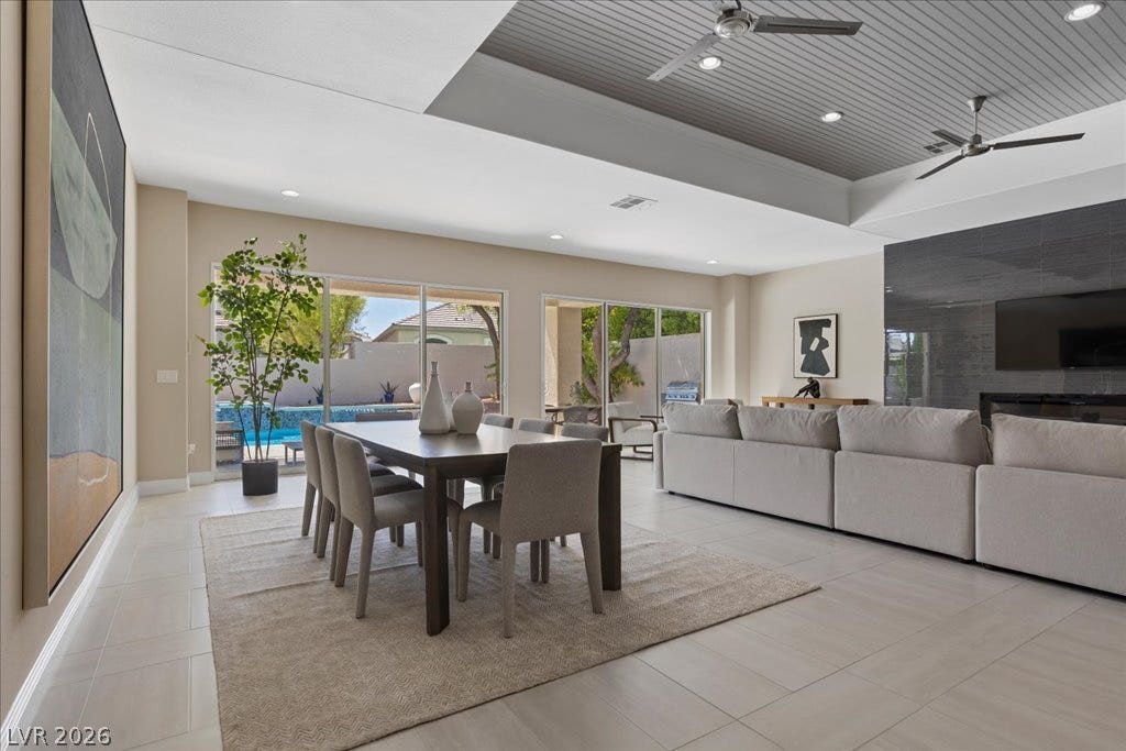 9425 Garnet Crown Avenue, Las Vegas, NV 89145 A spacious dining and living area opens seamlessly to the poolside patio through sliding glass doors.