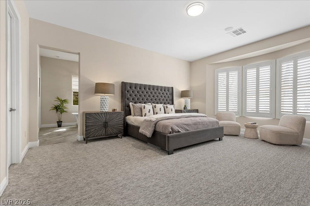 9425 Garnet Crown Avenue, Las Vegas, NV 89145 A spacious bedroom featuring soft wall-to-wall carpeting and elegant plantation shutters.