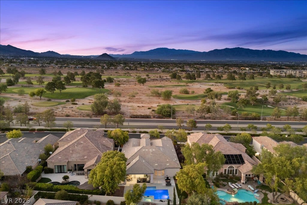 9425 Garnet Crown Avenue, Las Vegas, NV 89145 Majestic mountain ranges frame an expansive landscape overlooking a nearby golf course under twilight skies.