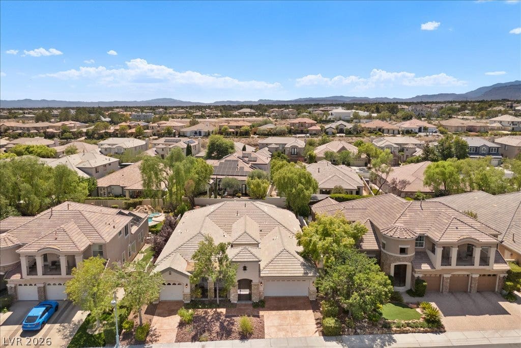 9425 Garnet Crown Avenue, Las Vegas, NV 89145 An aerial perspective showcases a tile-roofed home nestled in a quiet desert neighborhood.
