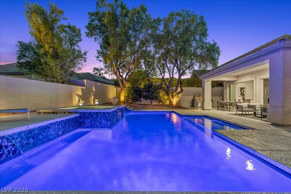 9425 Garnet Crown Avenue, Las Vegas, NV 89145 Mature trees and a covered patio frame this tranquil pool area beneath twilight skies.