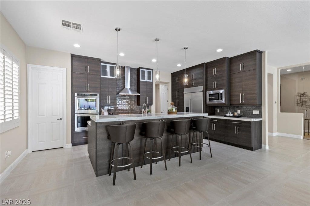 9425 Garnet Crown Avenue, Las Vegas, NV 89145 Sleek contemporary cabinetry and a massive island anchor this modern open-concept culinary space.
