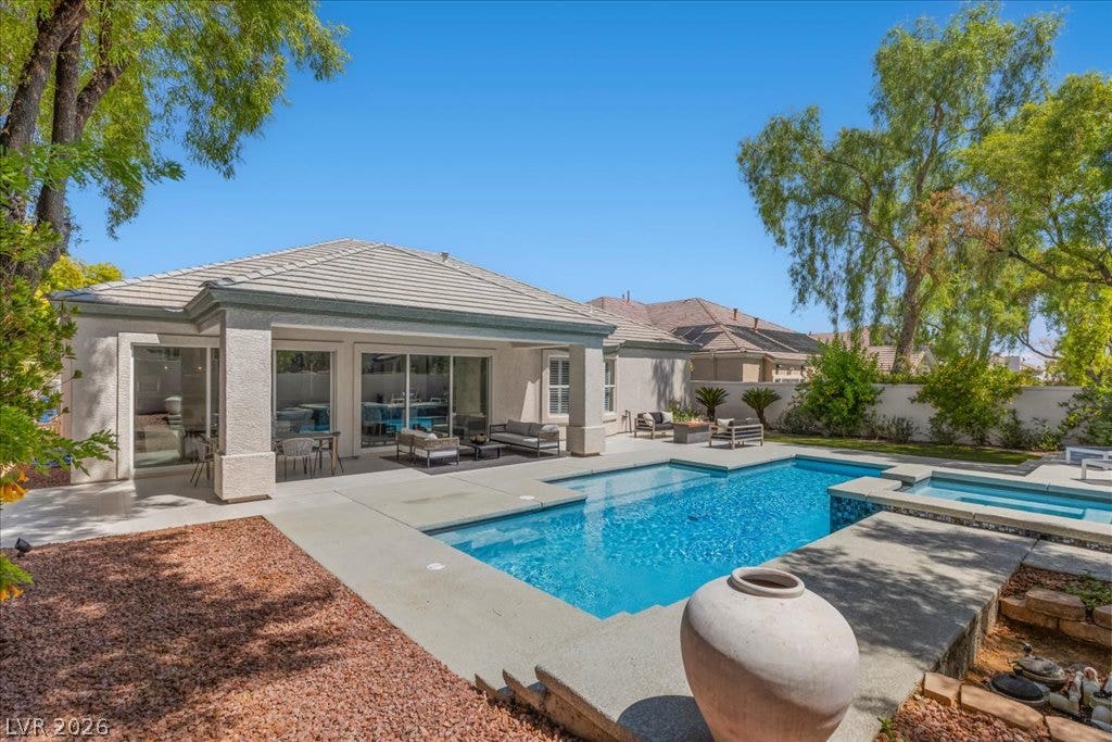 9425 Garnet Crown Avenue, Las Vegas, NV 89145 An inviting backyard oasis features a shimmering swimming pool paired with a raised spa.