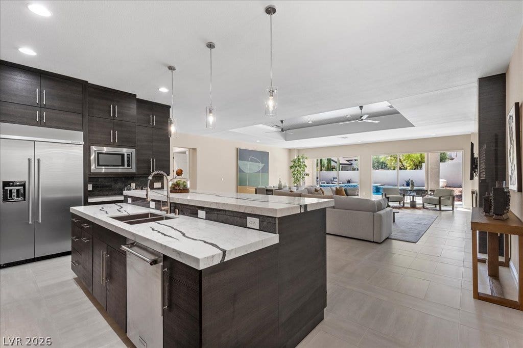 9425 Garnet Crown Avenue, Las Vegas, NV 89145 An open floorplan seamlessly connects the stone-countertop kitchen island to the bright living space.