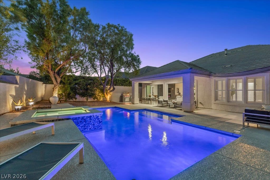 9425 Garnet Crown Avenue, Las Vegas, NV 89145 An inviting backyard oasis features a shimmering pool alongside a covered patio.