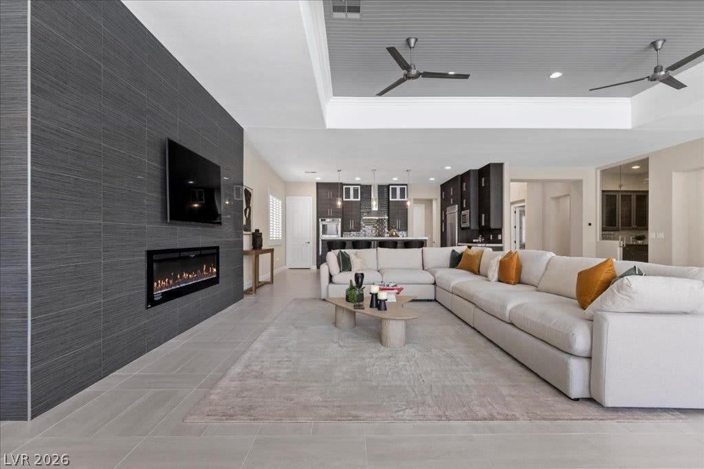 9425 Garnet Crown Avenue, Las Vegas, NV 89145 An open living space highlights a linear fireplace set within a textured accent wall.