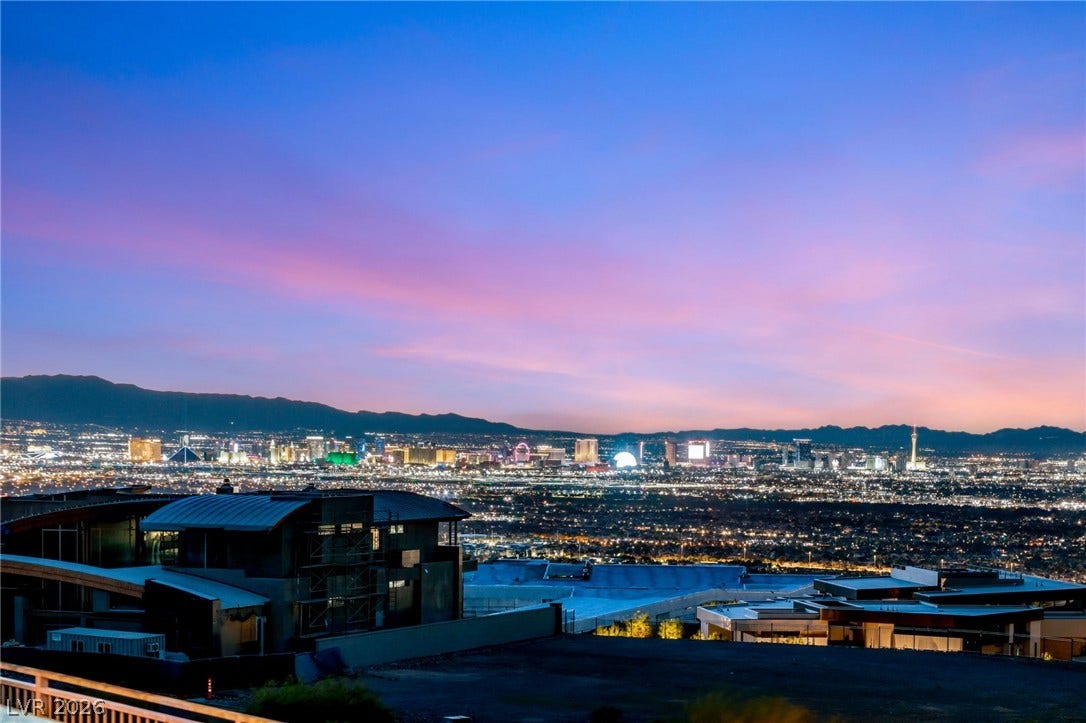 4 Chisel Crest Court, Henderson, NV 89012 Glittering city lights shimmer beneath a vibrant twilight sky from this elevated vantage point.