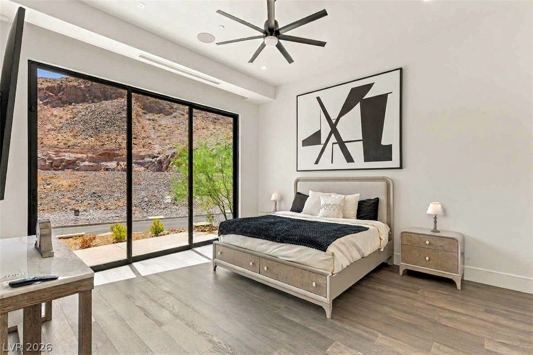 4 Chisel Crest Court, Henderson, NV 89012 Massive sliding glass doors reveal a rugged desert landscape from this modern bedroom.