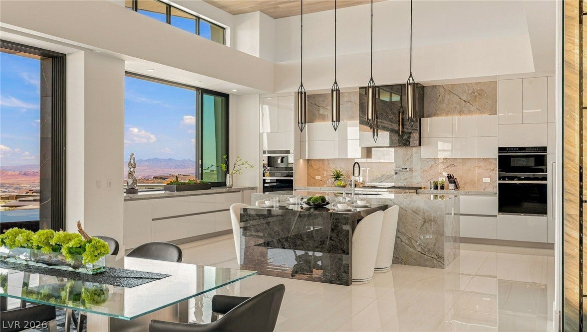 4 Chisel Crest Court, Henderson, NV 89012 High ceilings, stone countertops, and sliding doors framing mountain views define this modern culinary space.
