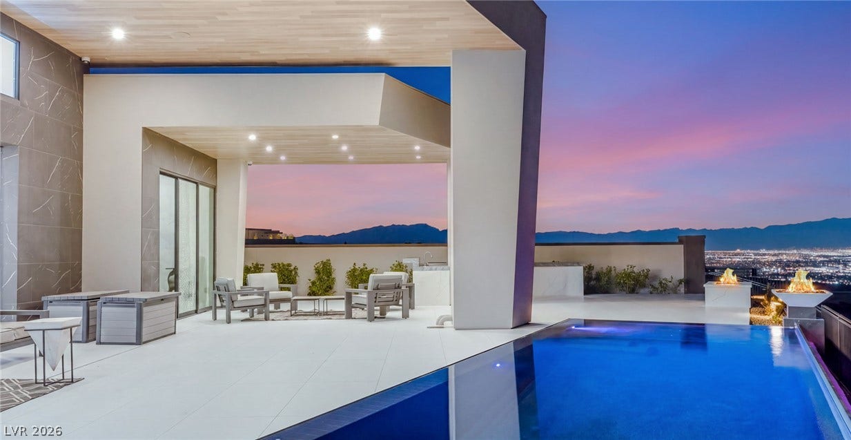 4 Chisel Crest Court, Henderson, NV 89012 An integrated pool and covered patio showcase panoramic mountain views under a twilight sky.