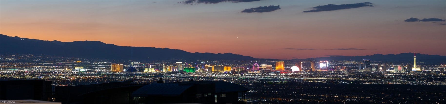 4 Chisel Crest Court, Henderson, NV 89012 Dusk settles over the glittering city skyline nestled against a backdrop of distant mountains.