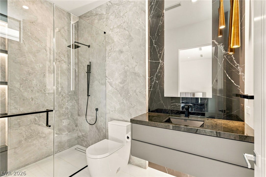4 Chisel Crest Court, Henderson, NV 89012 Polished stone surfaces and a glass-enclosed shower define this contemporary bath.